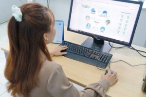Young woman using desktop computer in office setting in Hanoi, Vietnam.
