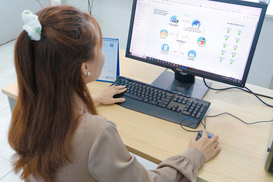 Young woman using desktop computer in office setting in Hanoi, Vietnam.